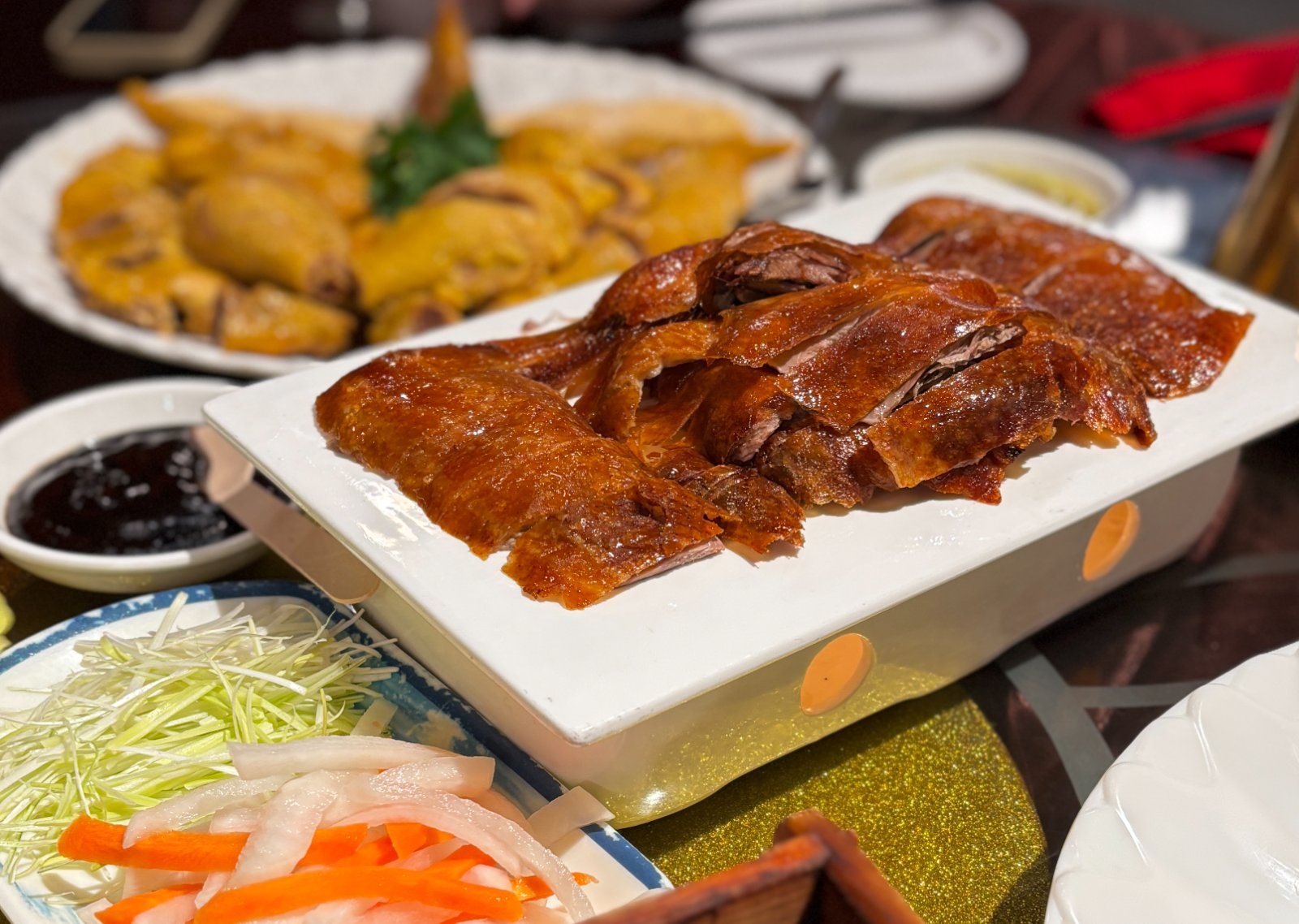 Canard de Pékin tranché sur la table, servi avec crêpes et condiments