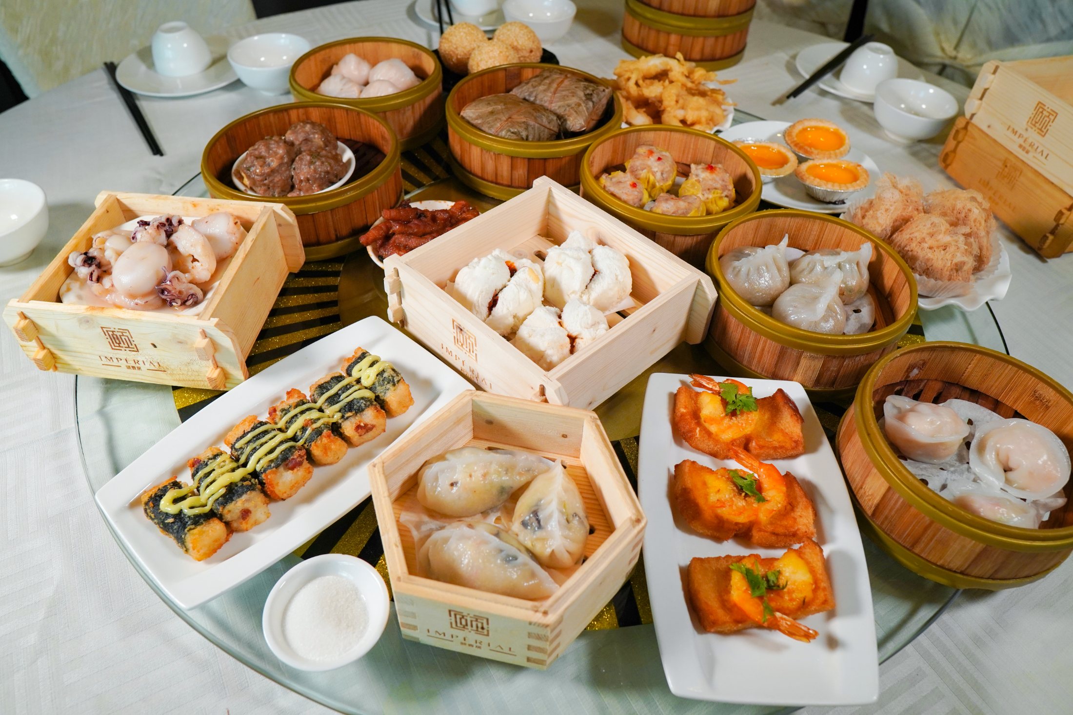 Table de dim sum dressée — paniers de bambou, raviolis et tartes au flan